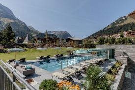 Outdoor Pool with the mountains of Arlberg | Snowy alps at the Hotel Arlberg Lech, Austria 