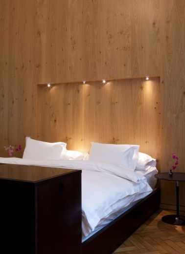 A luxe hotel bed with down lighting by Adolf Krischanitz for Hotel Altstadt's interior design of room 64
