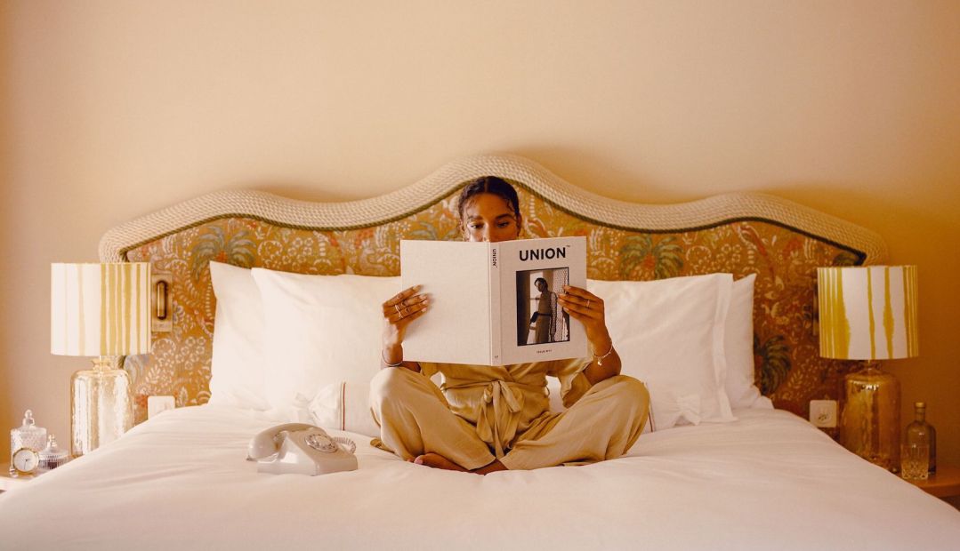 Luxury Design - person reading in bed holding a book | Beausite Boutique Hotel | Best Views of the Matterhorn in Zermatt