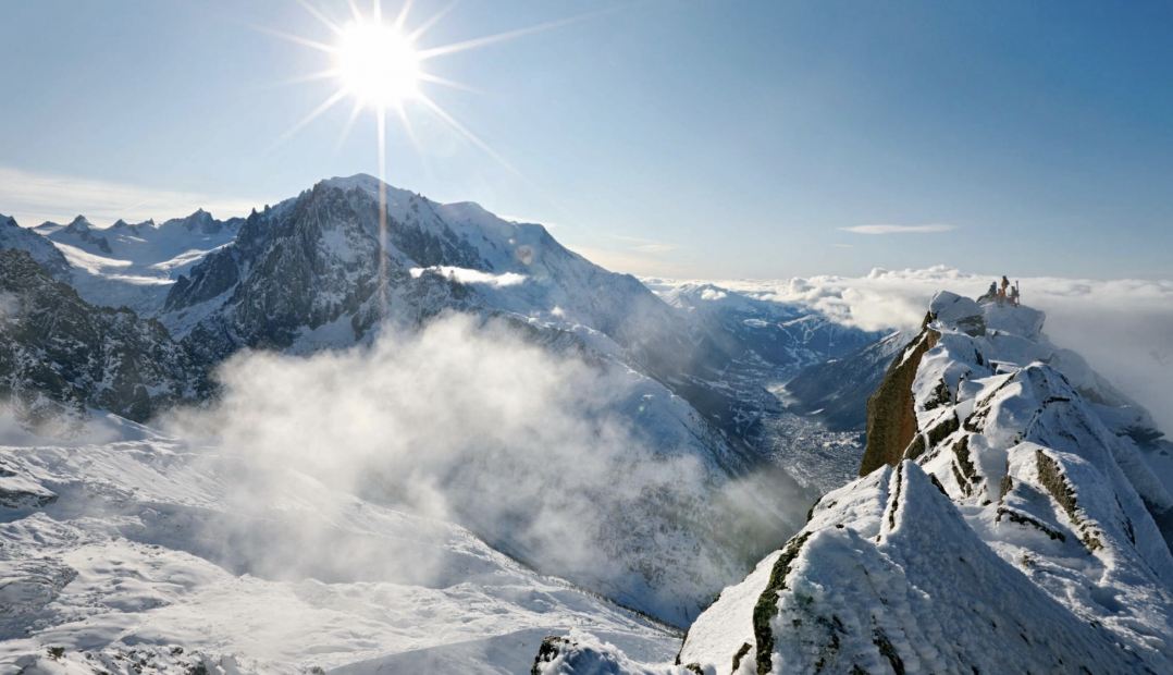A photo of the sun rising of snowy mountain peaks in the Alps - Maloja Clothing